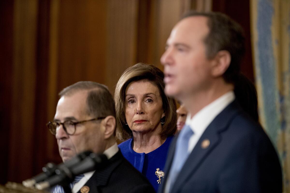 House Speaker Nancy Pelosi watches as Reps. Jerrold Nadler, left, and Adam B. Schiff speak at Tuesday's news conference announcing articles of impeachment against President Trump.