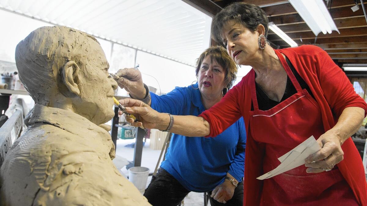 Sculptors Miriam Baker, right, and Rhonda Jones work on a sculpture of now-deceased Balboa Island couple Herman and Lois Dorkin.