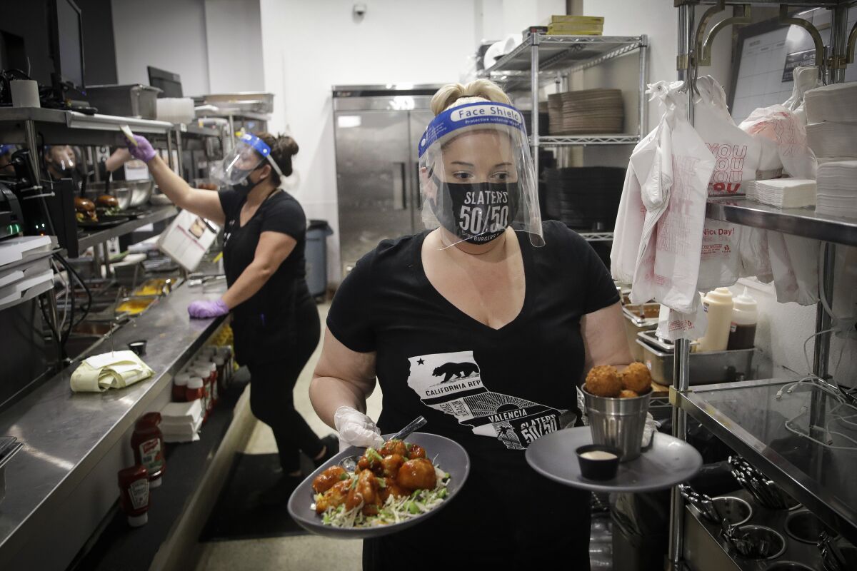 A waitress takes a food order from the kitchen at Slater's 50/50 in Santa Clarita.
