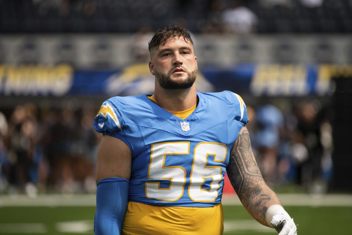 The Chargers' Morgan Fox (56) stands on the field with his helmet off.