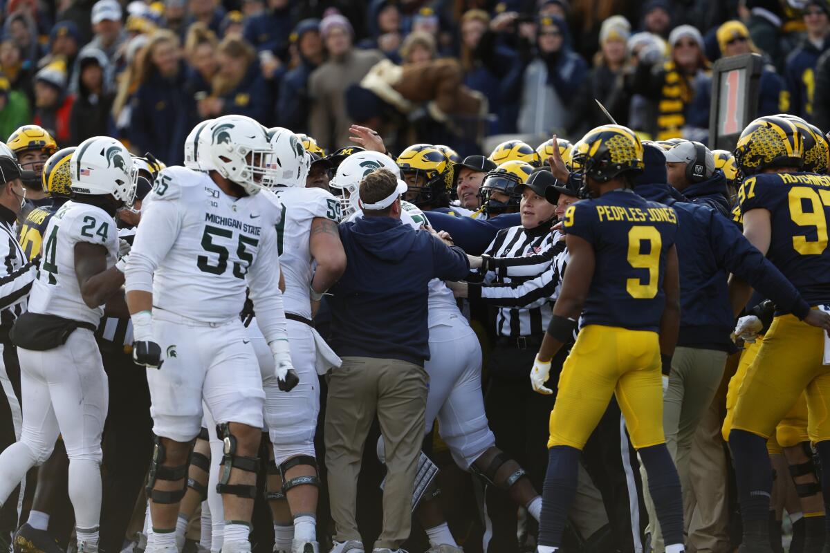 Officials separate Michigan State and Michigan players during a scuffle in the second half of a game Nov. 16.