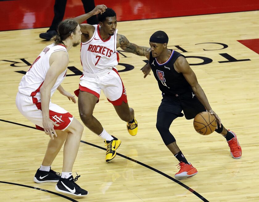 The Clippers' Rajon Rondo drives against the Rockets' Armoni Brooks (7) and Kelly Olynyk on May 14, 2021.
