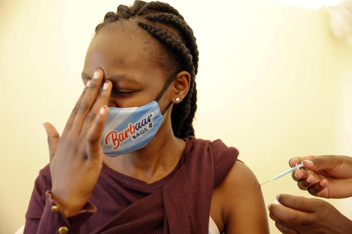 A woman receives a dose of AstraZeneca COVID-19 vaccine manufactured by the Serum Institute of India and provided through the global COVAX initiative, at Kenyatta National Hospital in Nairobi, Thursday, April 8, 2021. (AP Photo/Brian Inganga)