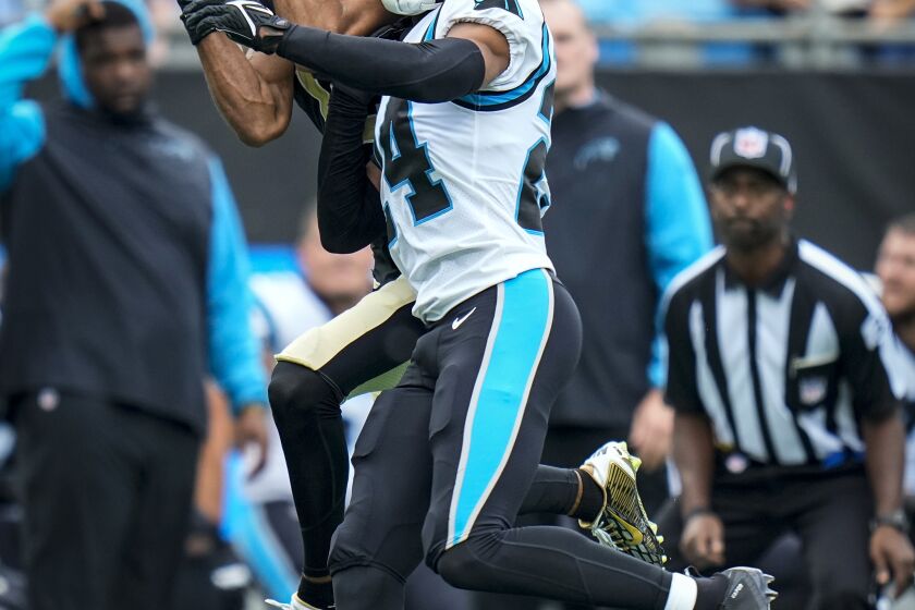 New Orleans Saints wide receiver Chris Olave (12) attempts a catch over Carolina Panthers cornerback CJ Henderson (24) during an NFL football game on Sunday, Sep. 25, 2022, in Charlotte, N.C. (AP Photo/Rusty Jones)