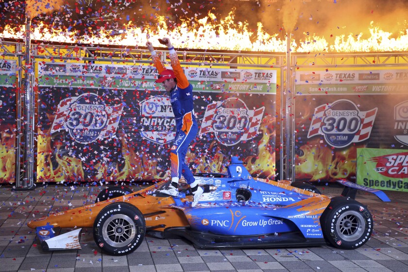 Scott Dixon jumps off his car as he celebrates winning the IndyCar Series auto race at Texas Motor Speedway on Saturday, May 1, 2021, in Fort Worth, Texas. (AP Photo/Richard W. Rodriguez)