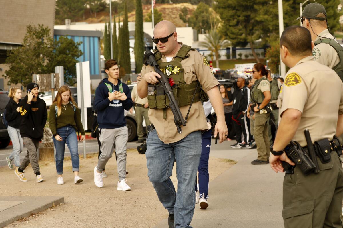 A sheriff's deputy leads students from the campus. Authorities said the gunfire lasted 16 seconds.