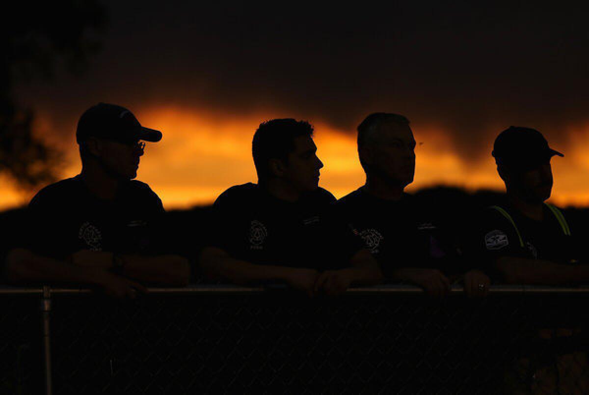 Firefighters attend a candlelight vigil in Prescott, Ariz., in honor of the 19 firefighters killed in the Yarnell Hill fire.