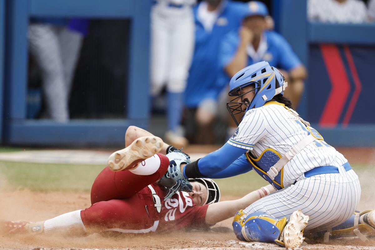 UCLA catcher Sharlize Palacios tags out Alabama's Kali Heivilin at the plate.
