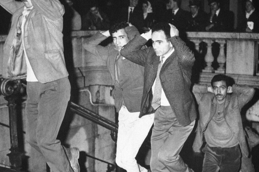 FILE - Men come out of Paris subway station with their hands on their heads after being arrested in Paris, Oct. 17, 1961, for failure to obey curfew imposed on Algerians. Algerians and wounding at least four. French lawmakers on Thursday March 28, 2024 condemned an infamous 1961 police crackdown on Algerian protesters in Paris as a "bloody and murderous repression," marking another step in the country's recognition of the massacre that authorities sought to cover up for decades. (AP Photo, File)