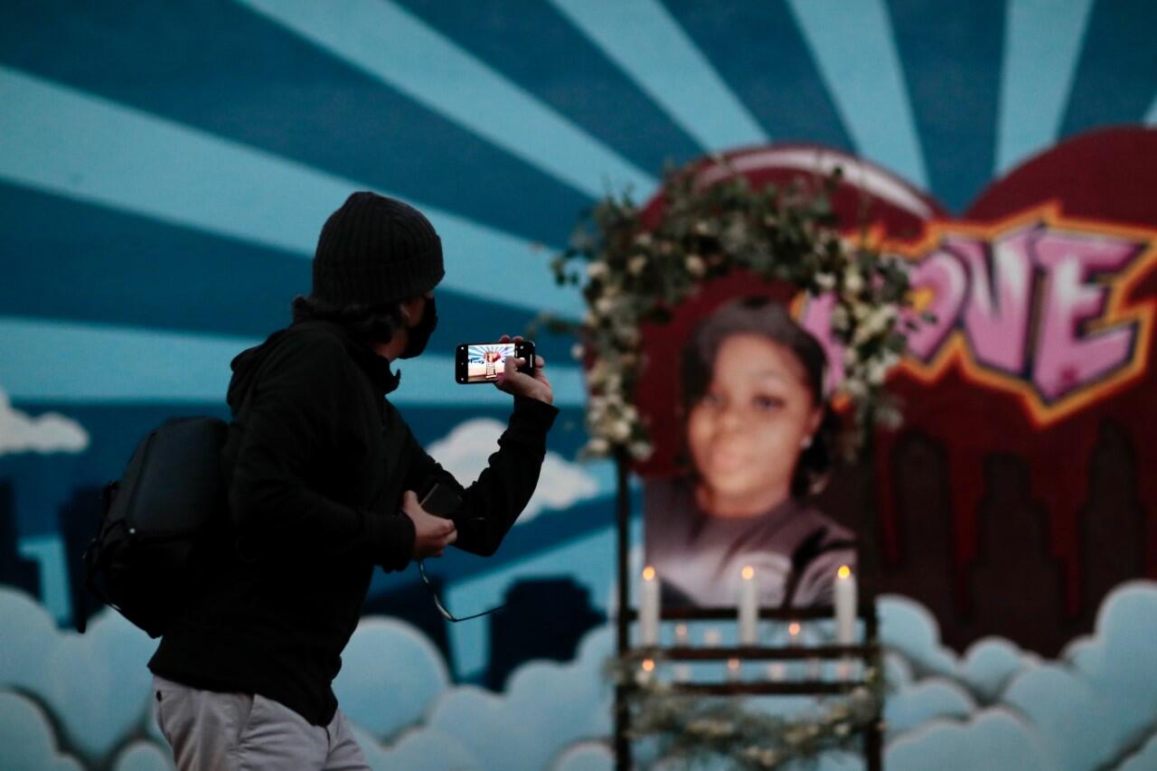 Candles are lit under an image of Breonna Taylor