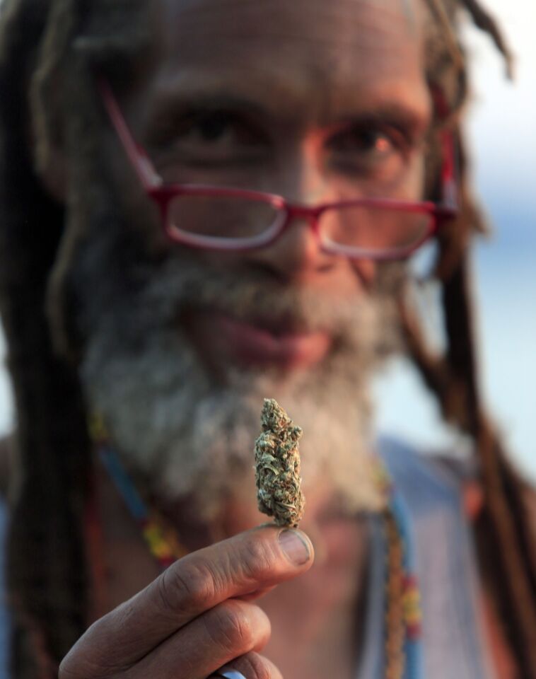 A man calling himself "Magic" offers a sample of his marijuana, now legal in Washington, for sale in Victor Steinbrueck Park next to the market.