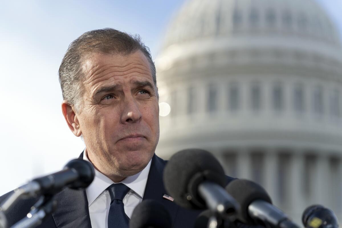 Hunter Biden stands before a bank of microphones, the U.S. Capitol dome behind him