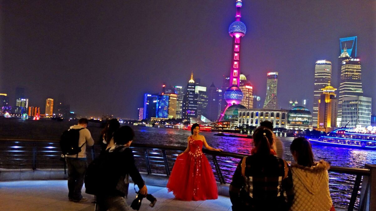 A bride poses along the waterfront in Shanghai.