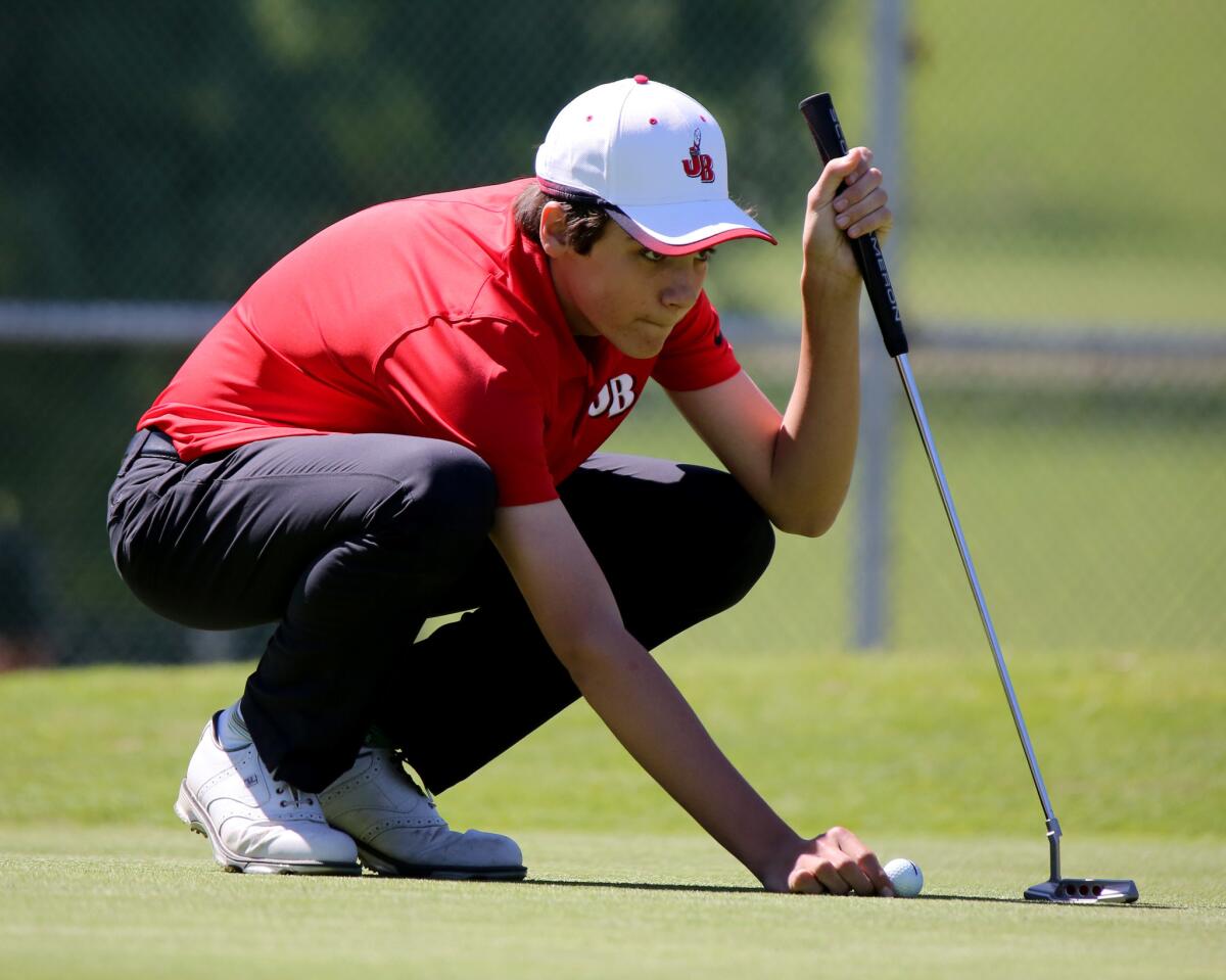 Burroughs High School freshman Lincoln Melcher lines up his shot on the green during Pacific League play at Harding Golf Course in Los Angeles on Thursday, March 14, 2019.