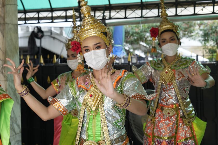 Thai classical dancers wearing face masks to help protect themselves from the coronavirus perform at the Erawan Shrine in Bangkok, Thailand, Monday, Feb. 7, 2022. (AP Photo/Sakchai Lalit)