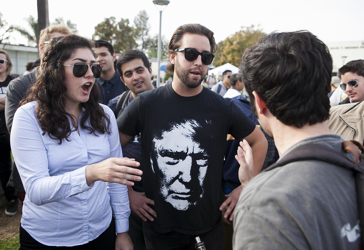 Ariana Rowlands, president of the College Republicans at UC Irvine, and Andrew Cavarno debate with a student at a rally concerning comments by Orange Coast College professor Olga Perez Stable Cox, in this file photo taken Dec. 12, 2016.