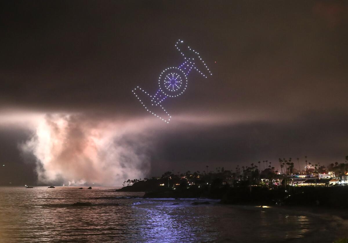 A group of drones take the shape of a Star Wars jet fighter as part of the Fourth of July drone show in Laguna Beach.