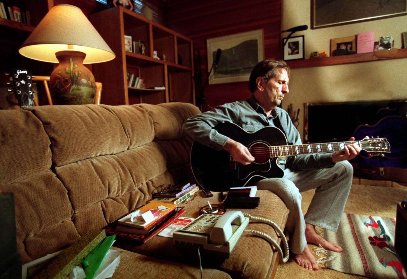 Stanton plays guitar in his home in 1997.
