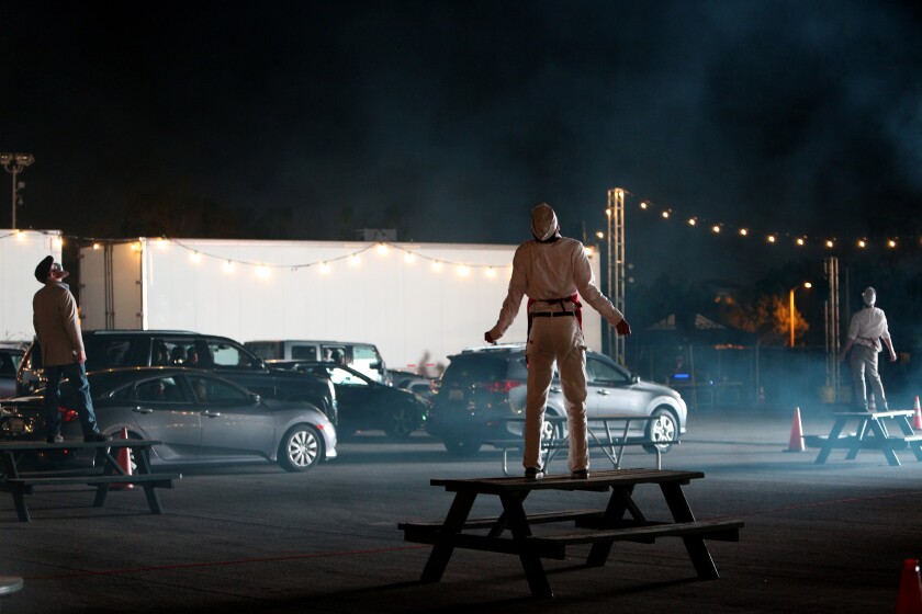Actors pose as cars stop during the drive-through "Urban Legends of Southern California"