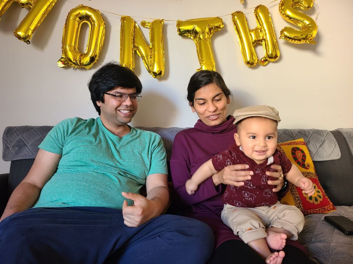 Swati Tyagi sits with her husband, Ashim Rai, and 11-month-old son, Miransh.
