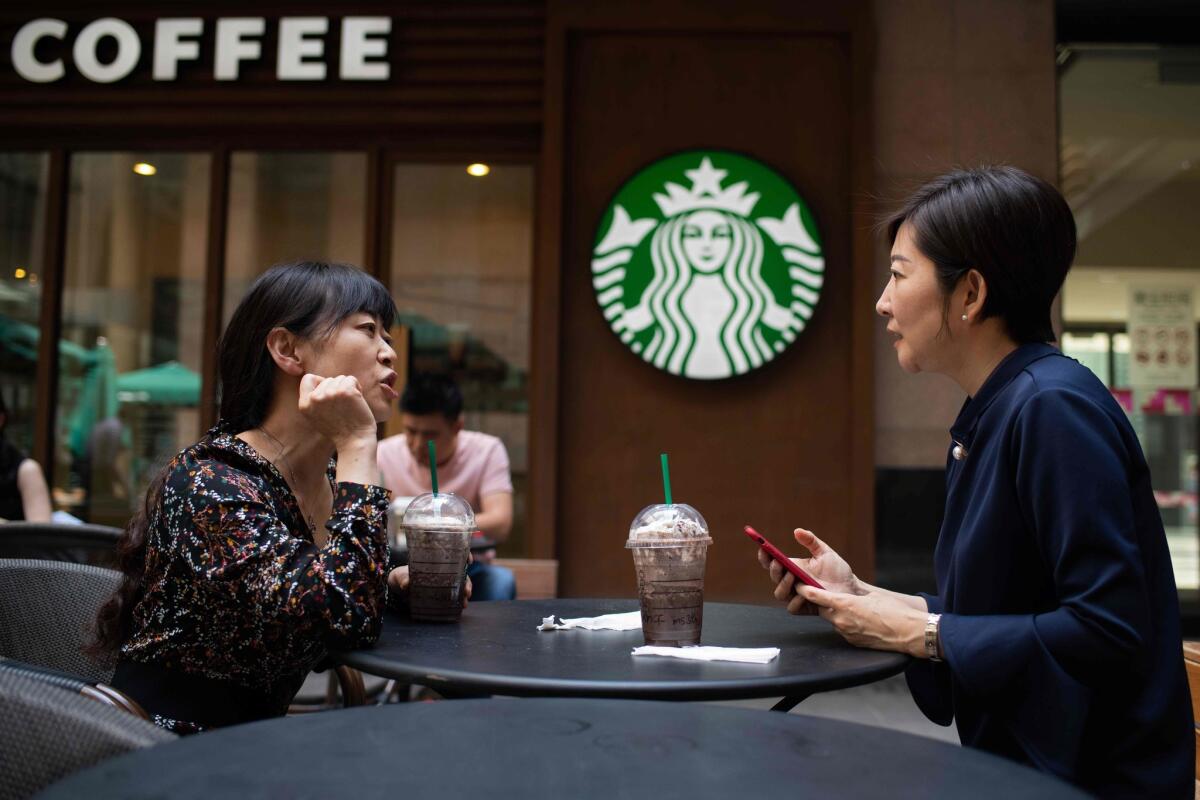 Women talk at a Starbucks in China
