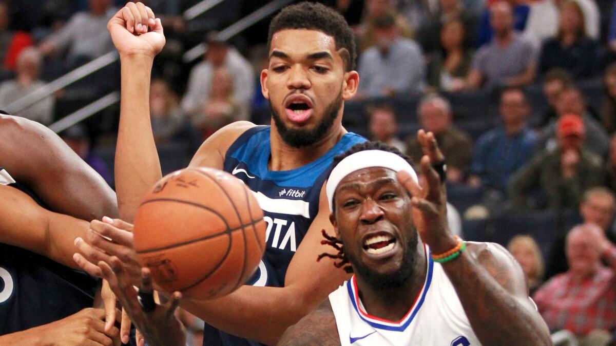 The Clippers' Montrezl Harrell, right, battles for a rebound with Minnesota's Karl-Anthony Towns on Dec. 3.