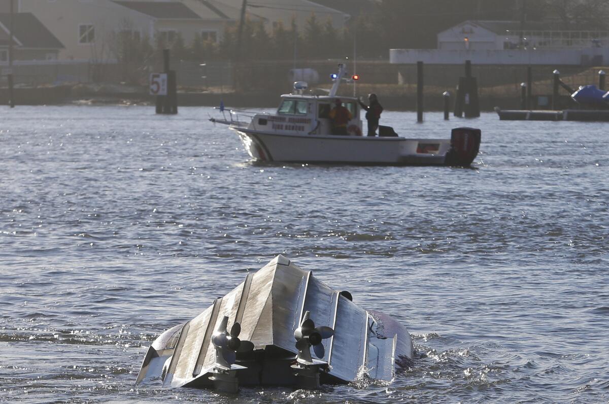 A fire rescue boat passes a Coast Guard vessel that overturned Thursday in the Queens borough of New York.