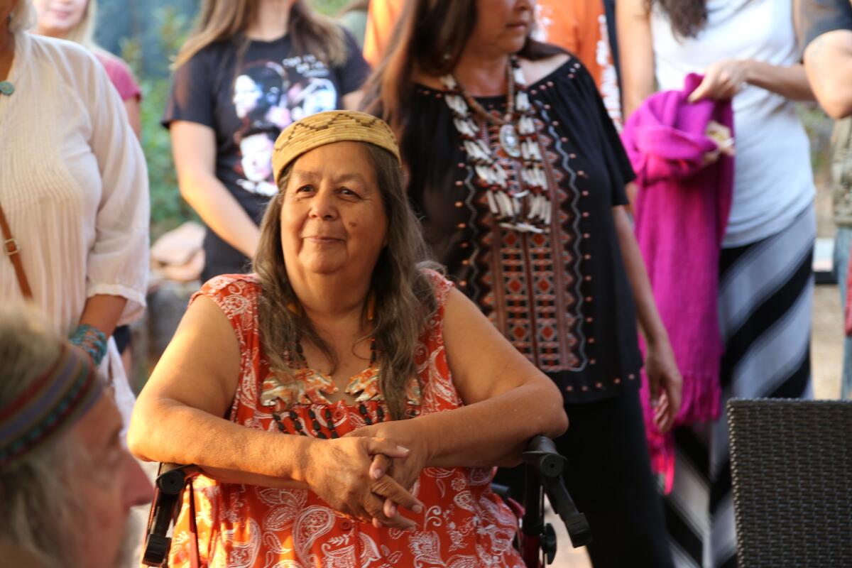 Julia Bogany, seated, wears a traditional hat.