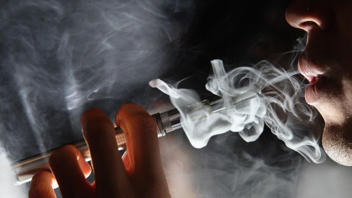 A vaper uses an electronic cigarette in London. A new study finds that smokers in England who used e-cigarettes had more success quitting traditional cigarettes.