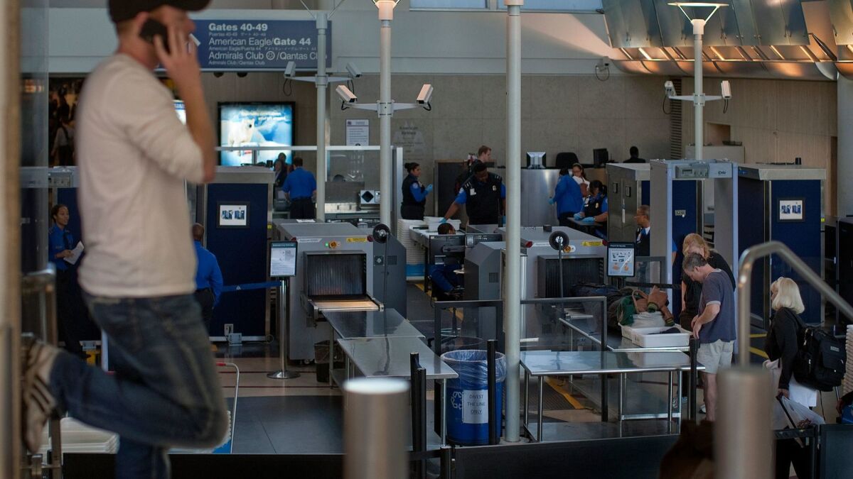 Transportation Security Administration officers screen passengers at Los Angeles International Airport.