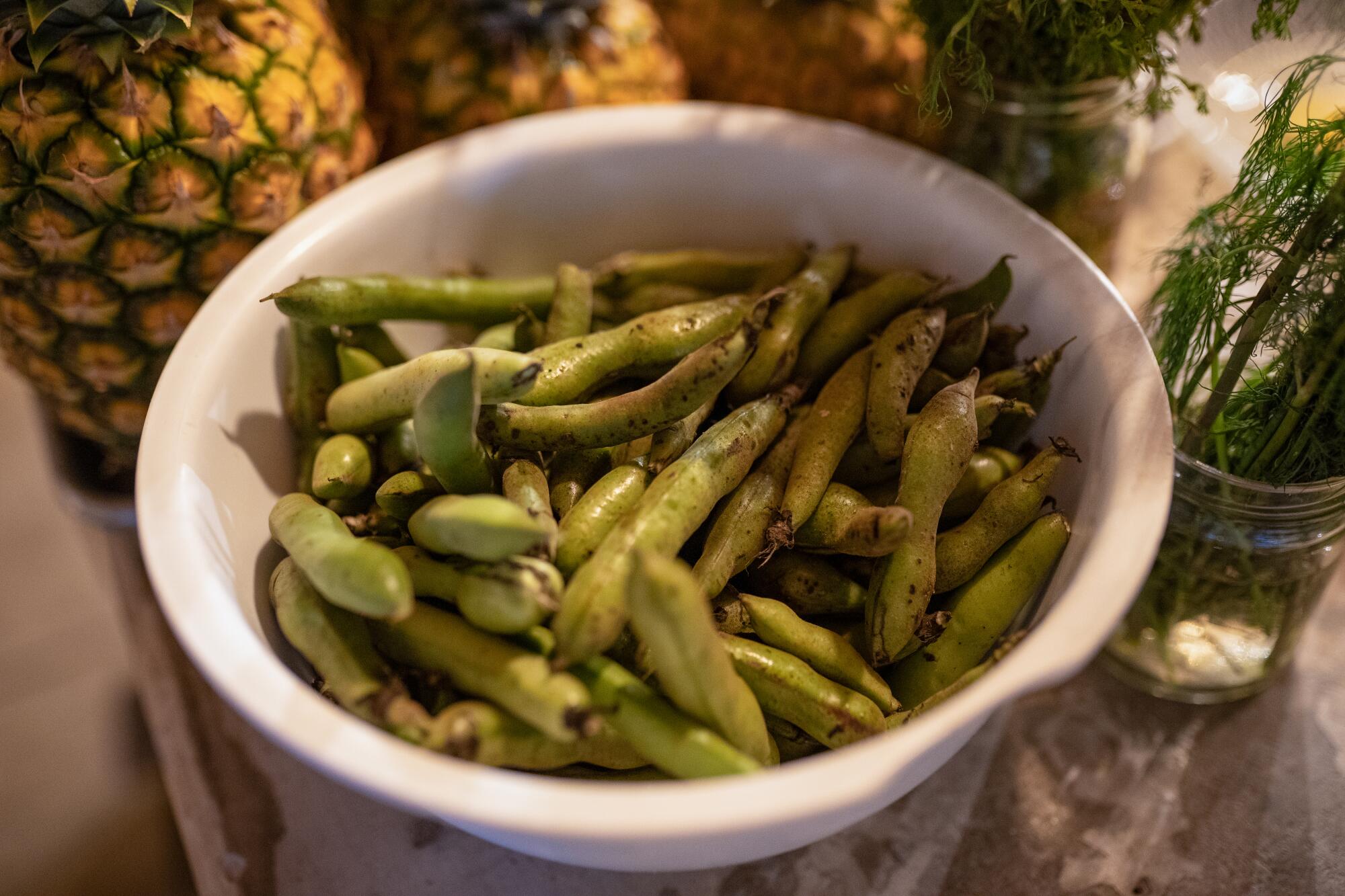 Bean pods in a white bowl