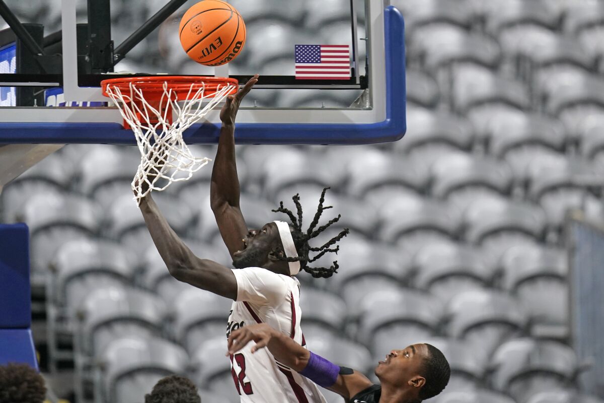 New Mexico State forward Yuat Alok, left, goes to the basket as Abilene Christian guard Damien Daniels defends during the first half of an NCAA college basketball game for the championship of Western Athletic Conference men's tournament Saturday, March 12, 2022, in Las Vegas. (AP Photo/Rick Bowmer)