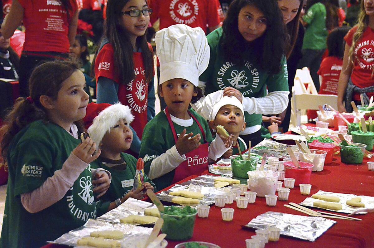 Several kids decorate cookies at the Christmas cookie decorating station which was one of the most popular events during the "Sharing the Spirit" holiday party" in Santa's Village at South Coast Plaza on Friday. The event was organized and put on by the Festival of Children Foundation and The Happiness Project and included around 600 underprivileged kids from Anaheim, Costa Mesa, Garden Grove, and Santa Ana, among other Orange County cities. Each child was given a gift bag upon arrival.