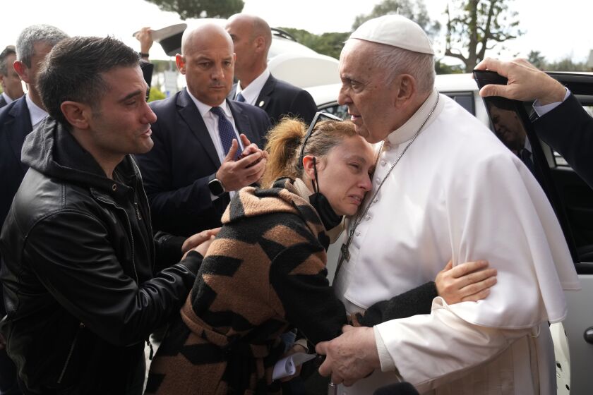 Pope Francis consoles Serena Subania and Matteo Rugghia, left, who lost their 5-year-old daughter Angelica yesterday, as he leaves the Agostino Gemelli University Hospital in Rome, Saturday, April 1, 2023, after receiving treatment for bronchitis, The Vatican said. Francis was hospitalized on Wednesday after his public general audience in St. Peter's Square at The Vatican. (AP Photo/Gregorio Borgia)