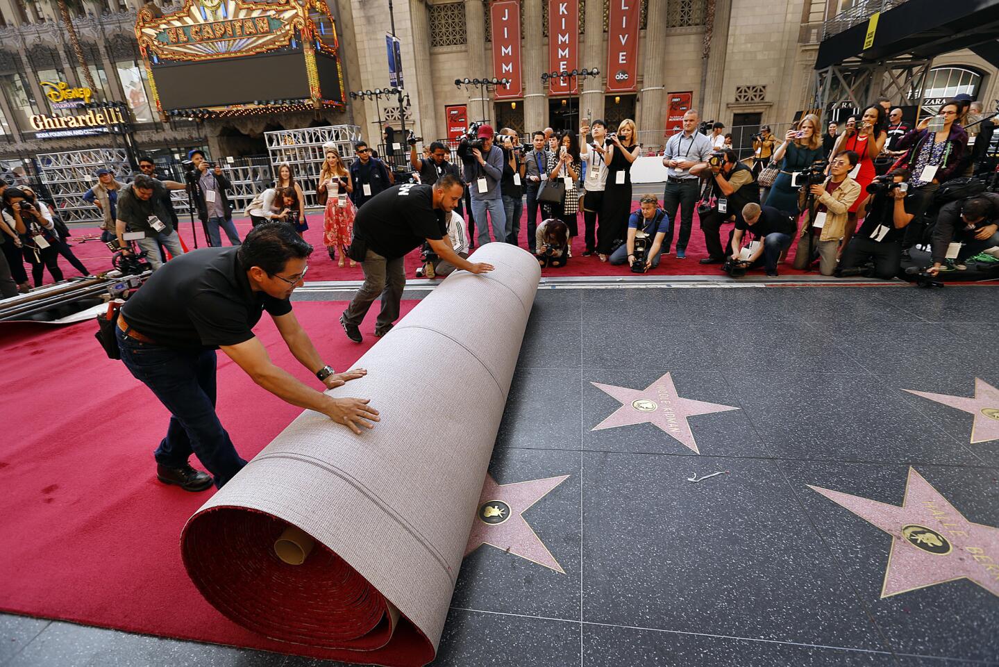Rodolfo Morales, left, and Eddie Padilla roll out a section of the red carpet on Hollywood Boulevard on Wednesday as media begin to congregate for the Oscars.