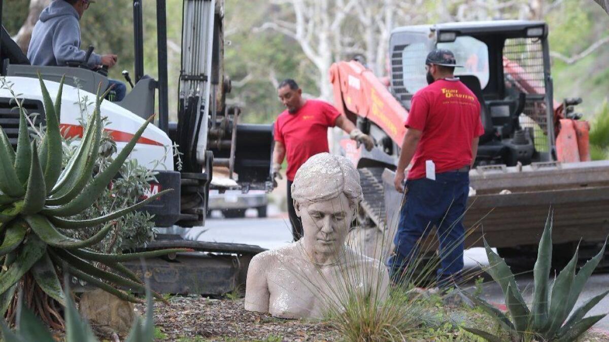 The head and shoulders of one of the "kneeling women" statues is removed from the front of the Laguna College of Art + Design campus Wednesday. The statues were originally part of a student project more than 10 years ago.