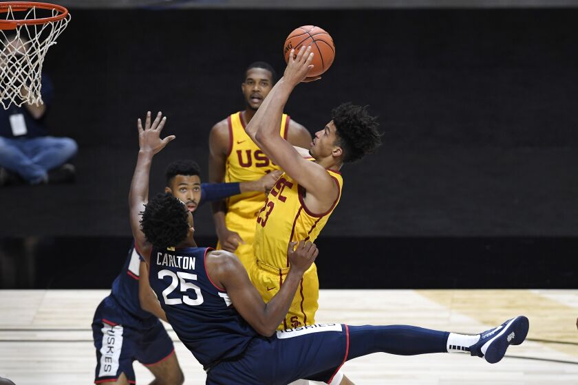 Connecticut's Josh Carlton (25) fouls Southern California's Max Agbonkpolo during the first half of an NCAA college basketball game Thursday, Dec. 3, 2020, in Uncasville, Conn. (AP Photo/Jessica Hill)