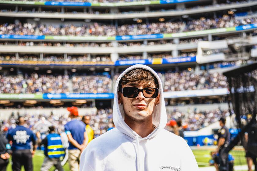 Peso Pluma con un uniforme de los Rams antes del partido en el SoFi Stadium.