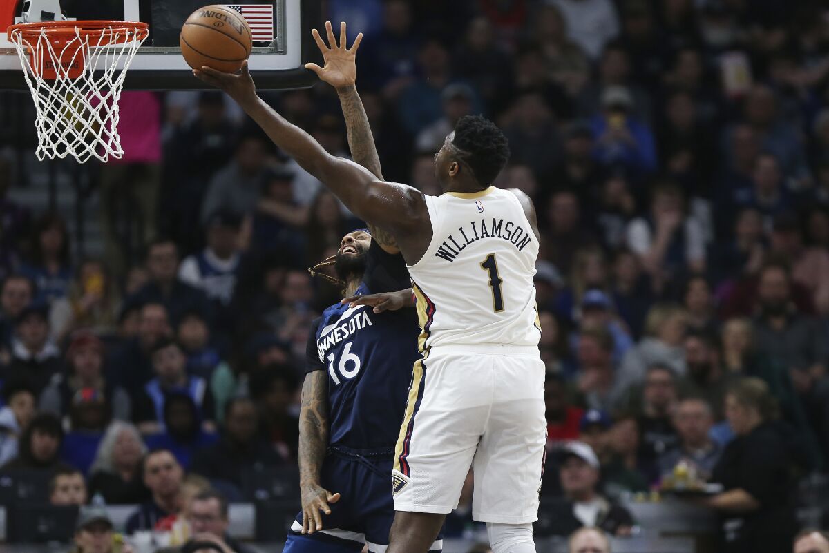 New Orleans Pelicans' Zion Williamson (1) shoots over Minnesota Timberwolves' James Johnson in the first half of an NBA basketball game Sunday, March 8, 2020, in Minneapolis. (AP Photo/Stacy Bengs)
