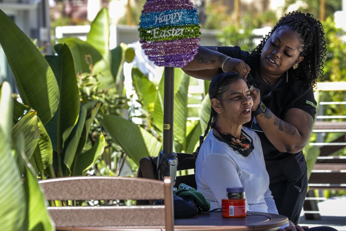 A woman gets her hair done at the Oasis, a new 40-bed interim housing recuperative care facility in Los Angeles.