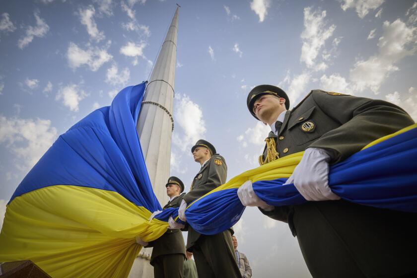 In this photo provided by the Ukrainian Presidential Press Office, honour guard soldiers prepare to rise the Ukrainian national flag during State Flag Day celebrations in Kyiv, Ukraine, Tuesday, Aug. 23, 2022. (Ukrainian Presidential Press Office via AP)