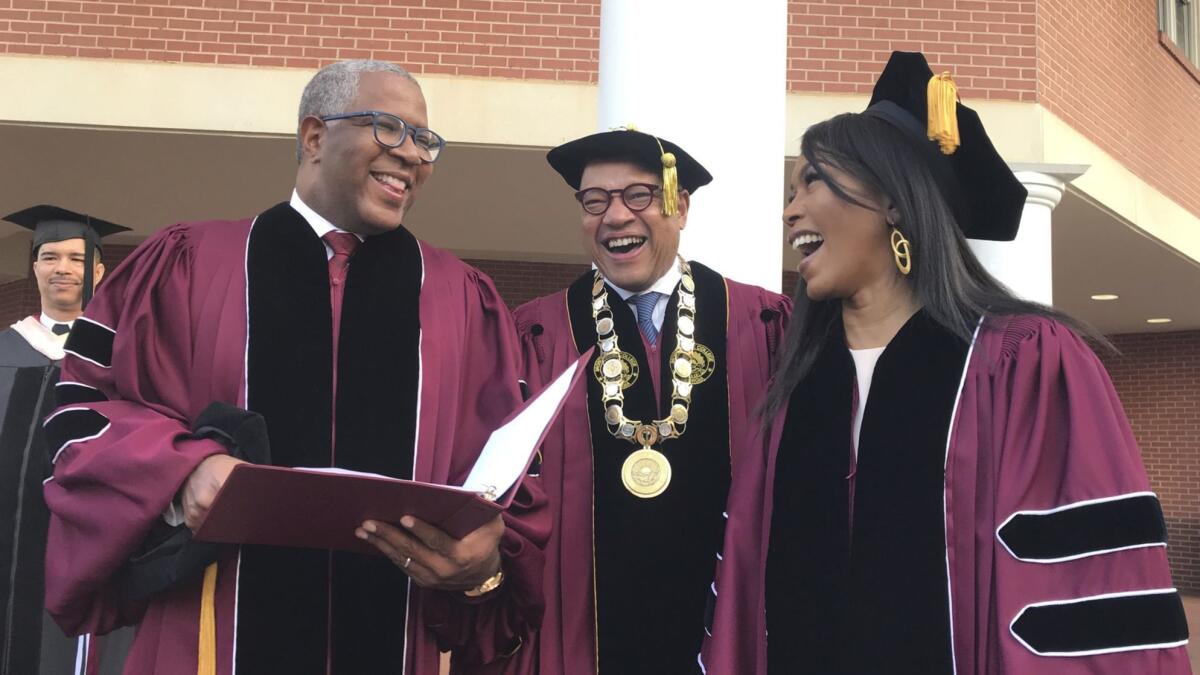 Billionaire investor Robert F. Smith, left, seen with Morehouse College President David Thomas and actress Angela Bassett at the college's commencement Sunday, at which Smith announced he would cover the student debt of the entire graduating class.