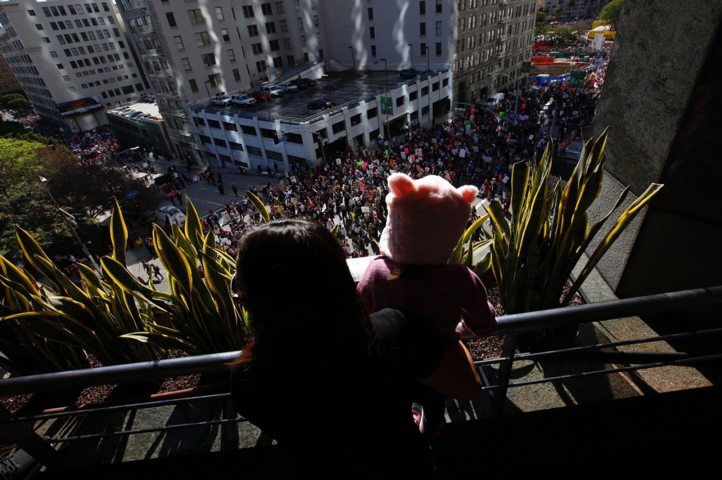 Gina Corpus, and her daughter Camila Corpus, 2, of Los Angeles watch the march for women's rights on Saturday.