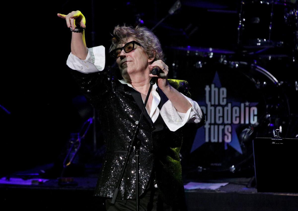 Psychedelic Furs frontman Richard Butler gestures to the crowd during performance at the Pacific Amphitheatre in Costa Mesa.