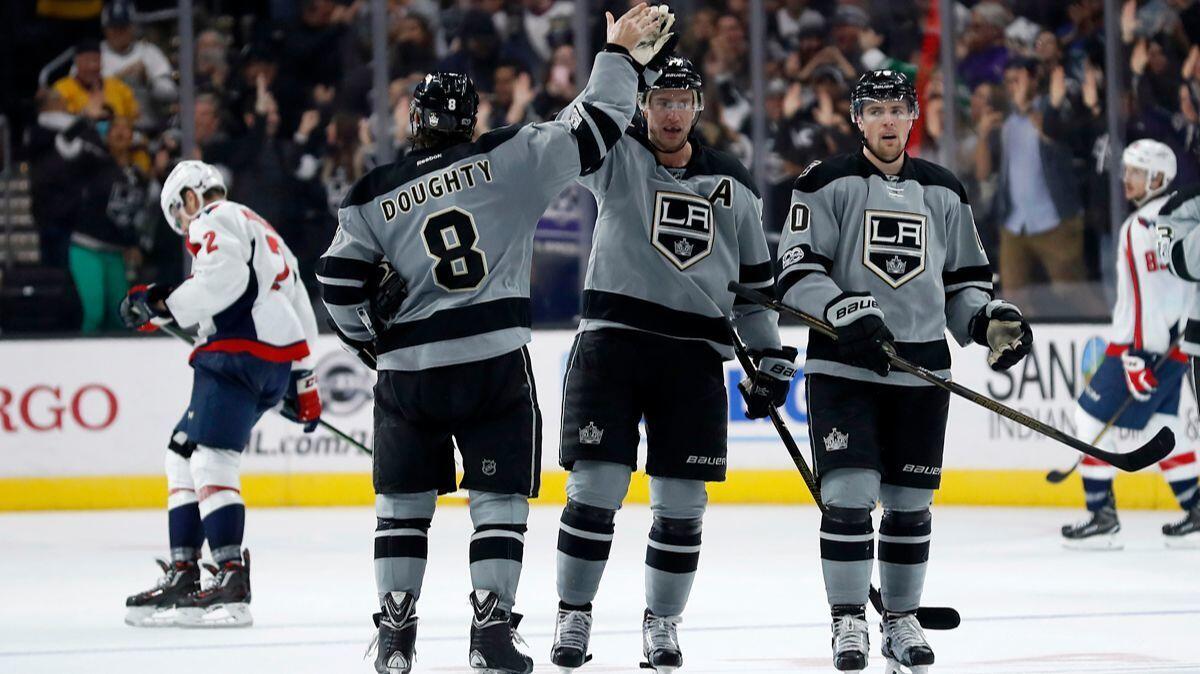 After scoring a goal against the Capitals on Saturday, Kings center Jeff Carter, center, high-fives defenseman Drew Doughty with left wing Tanner Pearson nearby.