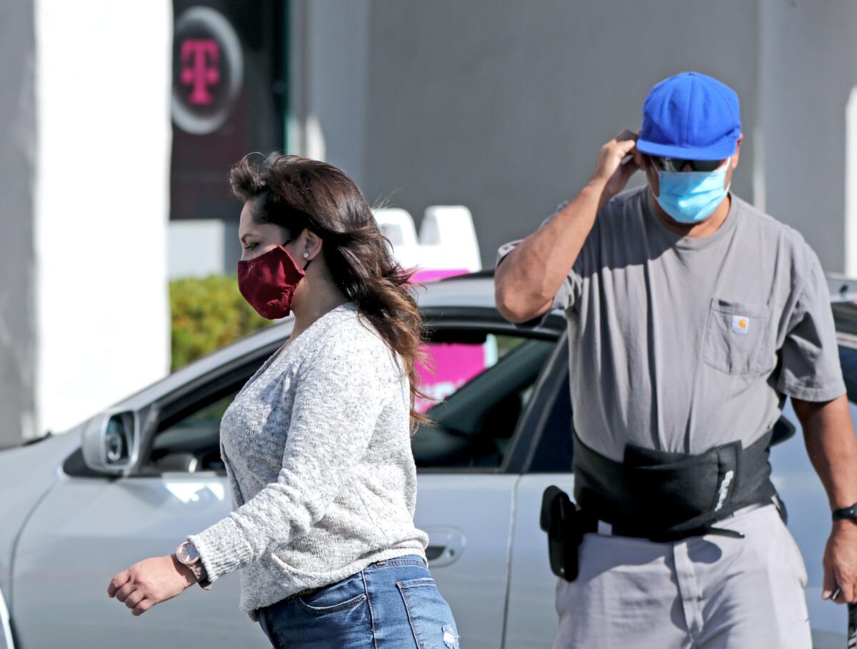 People wear their face masks while outside the 1800 block of Newport Boulevard in Costa Mesa on Nov. 14.