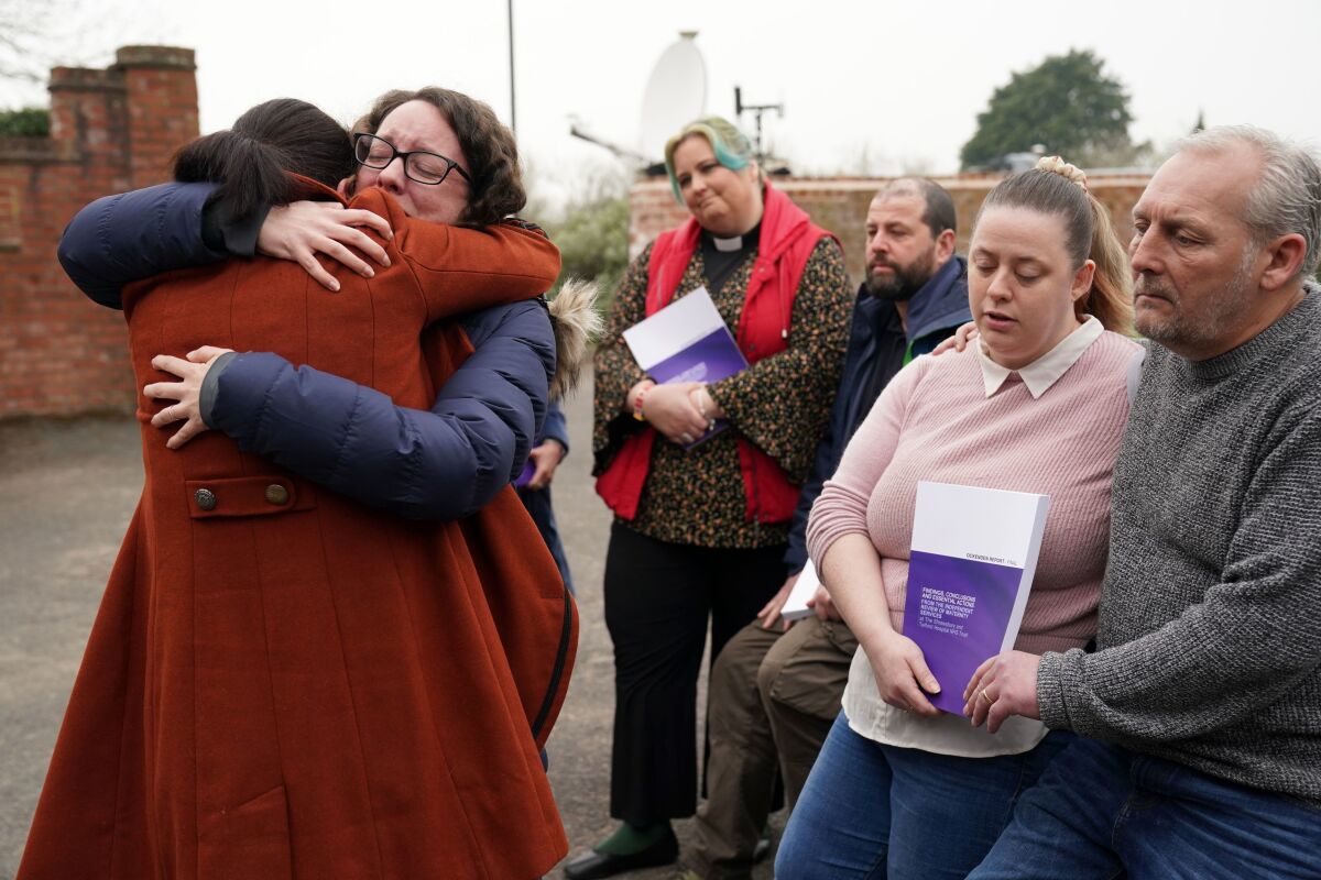 Rhiannon Davies, left, embraces Kayleigh Griffiths, following the release of the final report by Donna Ockenden, chair of the Independent Review into Maternity Services at the Shrewsbury and Telford Hospital NHS Trust, at The Mercure Shrewsbury Albrighton Hotel, Shropshire, England, Wednesday, March 30, 2022. A review into a scandal-hit British hospital group said Wednesday that persistent failures in maternity care contributed to the avoidable deaths of more than 200 babies over two decades. The review began in 2018 after two families that had lost their babies in the care of Shrewsbury and Telford NHS Trust in western England campaigned for an inquiry. (Jacob King/PA via AP)