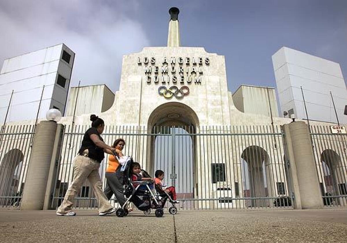 Maria Gonzales (left) walks her children with friend Victoria Guzman past the famous Los Angeles Coliseum in Exposition Park.