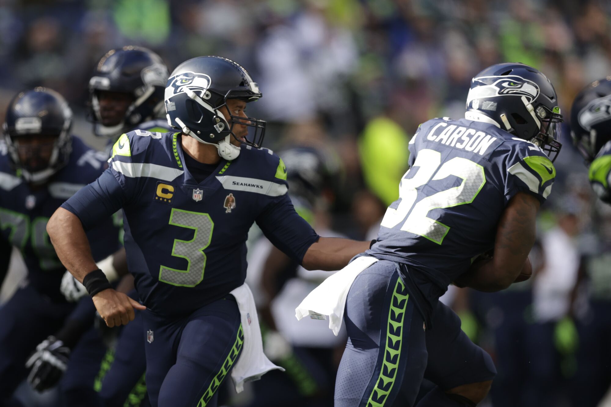 Seattle Seahawks quarterback Russell Wilson hands off to running back Chris Carson.