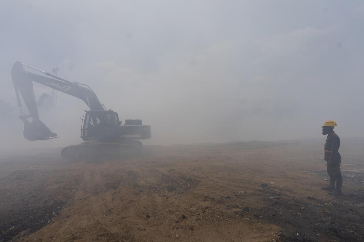 Un militar dirige una excavadora durante los trabajos para extinguir un incendio 